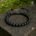 Armband aus mattem schwarzen Onyx auf Naturstein fotografiert – Symbol für Erdung, Stärke und Klarheit uniqal